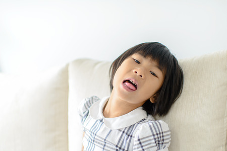 Asian girl open her mouth with candy inside.のeditorial素材