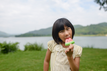 Asian girl eating ice cream in the park outdoor.の写真素材
