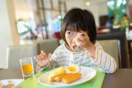 Asian girl eating breakfast with pajamas.の写真素材