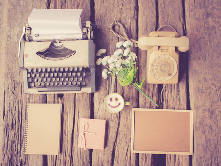 Typewriter coffee and notebook on the wood texture vintage color toneの写真素材