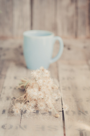 Bouquet of dried flowers and tea cup on wooded background.の写真素材