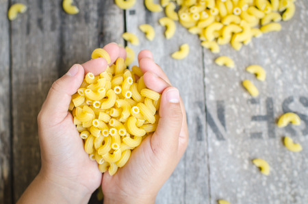 Italian Macaroni Pasta  in child hand.の写真素材