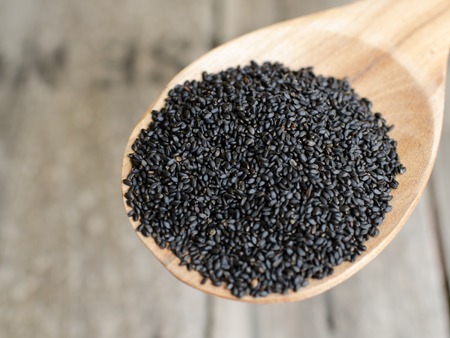 Black Sweet Basil seeds on wooden paddleの写真素材