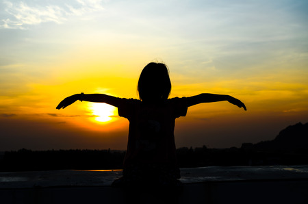 Young girl enjoying beautiful sun rise.の写真素材