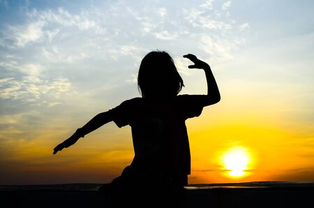 Young girl enjoying beautiful sun rise.の写真素材