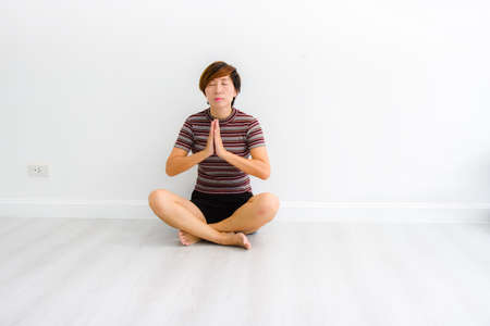 Smart Asian woman meditating indoors at home.の写真素材