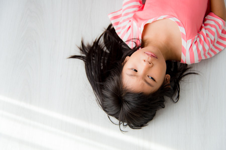 Asian girl lying on floor at home.の写真素材