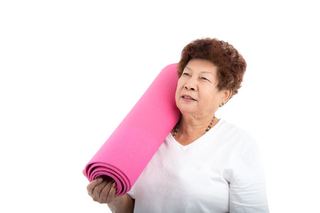 Asian senior woman holding pink yoga matの写真素材