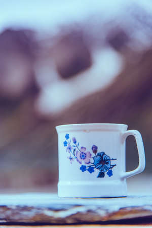White coffee cup with snow mountain background.  Vintage tone.の写真素材