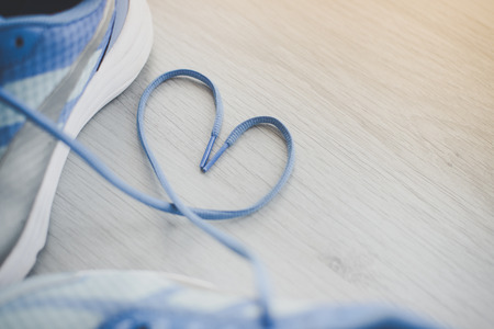 Love sign, Selective focus close up blue sport shoes on gray floor.