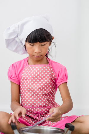 Asian child playing a chef at home.の写真素材