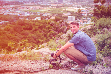 Young man sitting on the top of hill.