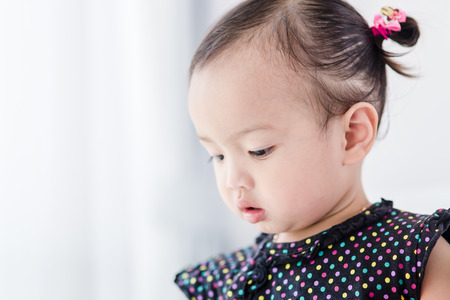 Closeup photo of beautiful cute asian baby's expression at home.の写真素材
