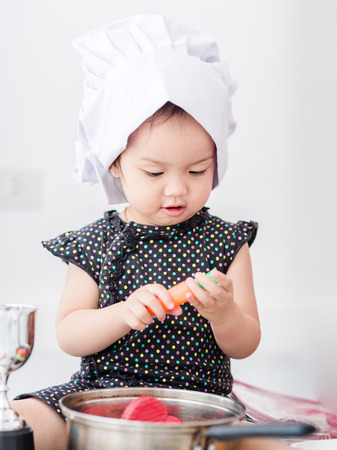 Asian child playing a chef at home.の写真素材