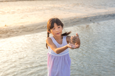 Asian girl playing on the beach with sun light.の写真素材