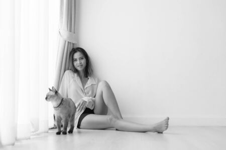 Black and white Asian woman with her cat on the floor at homeの写真素材