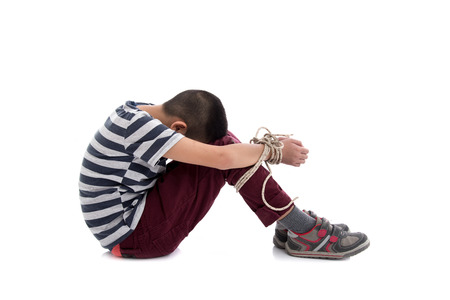 Missing kidnapped, abused, hostage, victim boy with hands tied up with rope in emotional stress and pain, afraid, restricted, trapped, call for help, struggle, terrified,の写真素材