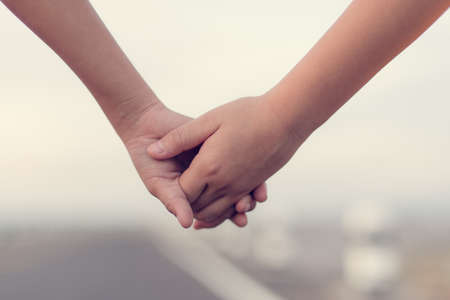 Hands holding together, boy and girl holding hands.  Depth of fieldの写真素材