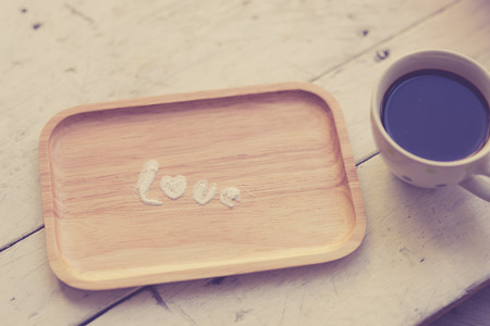 Love message by icing powder with coffee cup with warm light.の写真素材