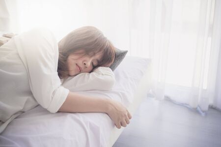 Portrait of a teenage girl laying in the bedの写真素材