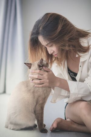 Asian woman with her cat on the floor at homeの写真素材