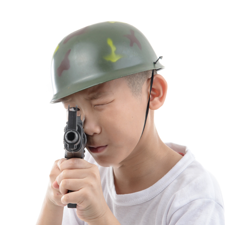 Asian boy with gun isolated on white background, childhood dream's conceptの写真素材