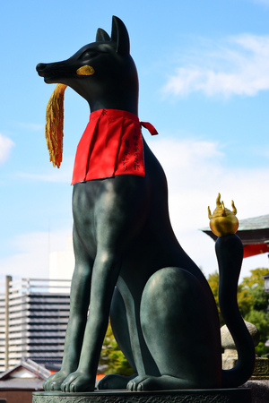 Fox holding rice paddy in its mouth, at the main gate of the Fushimi Inari Shrine Almost all Inari shrines have at least a pair of these statues in Kyoto, Japanのeditorial素材
