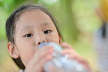 little girl drinks mineral waterの写真素材