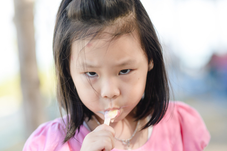 Portrait of Asian girl eating an ice-creamの写真素材