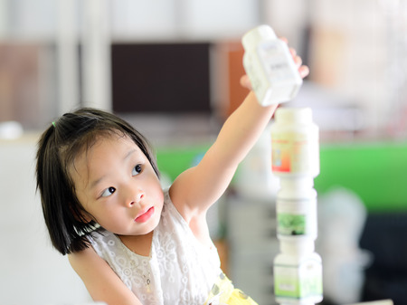 Asian girl playing block by plastic bottle at home, lifestyle conceptの写真素材