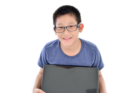 Asian boy with laptop sitting on white backgroundの写真素材