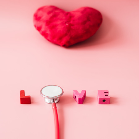 Stethoscope with love on red heart shape background.の写真素材