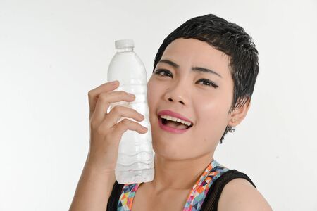 Smart Asian woman holding a bottle of water, healthy concept.の写真素材