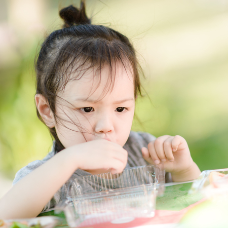 Asian girl eationg sausage in the park outdoor.の写真素材