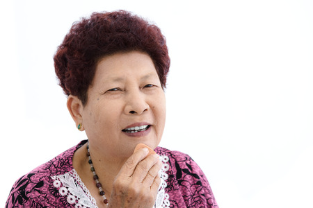 Asian senior woman make up her face on white background.
