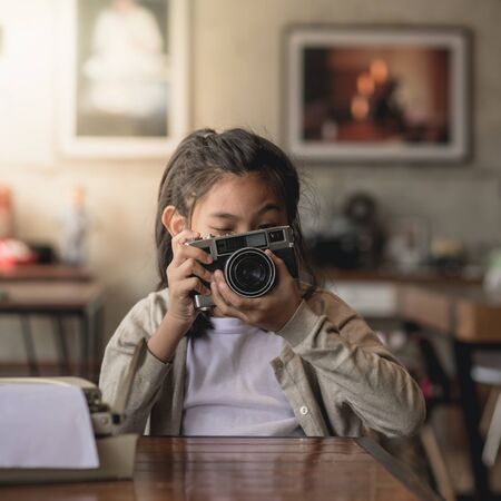 Happy Asian girl holding vintage camera in cafe, lifestyle concept.の写真素材