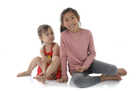 Happy Asian girl and her younger sister on white background.の写真素材