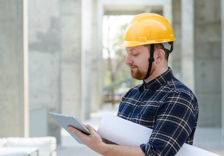 Male engineer at a construction site with a tablet computerの写真素材