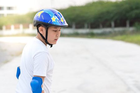 Boy learning skating outdoor, sweats on his face.の写真素材