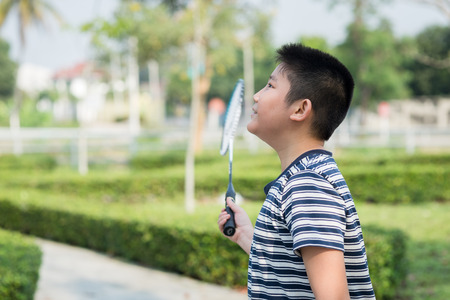 Happy Asiang boy playing badminton outdoor.の写真素材