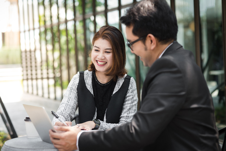 Business woman sitting at cafe outdoor and discussing with her team.の写真素材