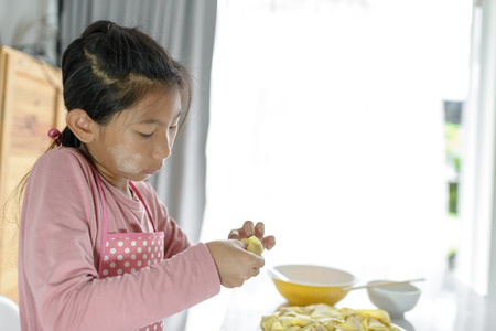 Girl processing homemade dumpling in her hand, lifestyle concept.  Selective focus.の写真素材