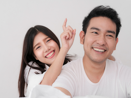 Happy Asian couple on the bed at home, lifestyle concept.の写真素材