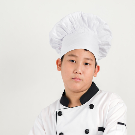 Asian preteen boy in chef unifor isolated on white background.の写真素材