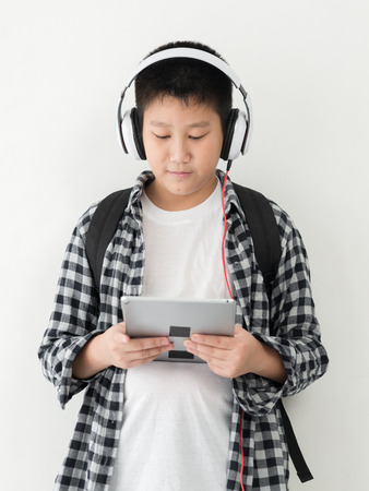 Happy Asian school boy using headphone and backpack, lifestyle concept.の写真素材