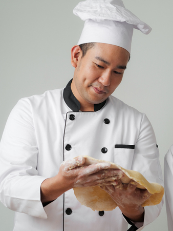 Asian chef holding dough in his hands, work lifestyle concept.の写真素材