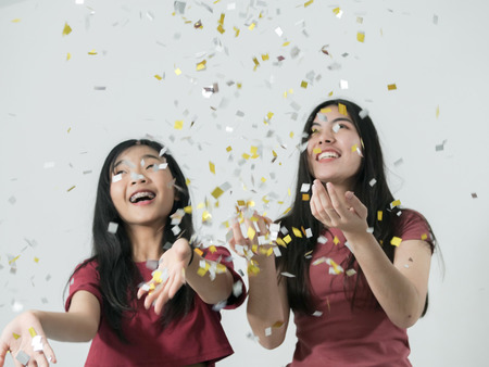 Happy Asian teenager girls with glitters falling down, lifestyle concept.の写真素材