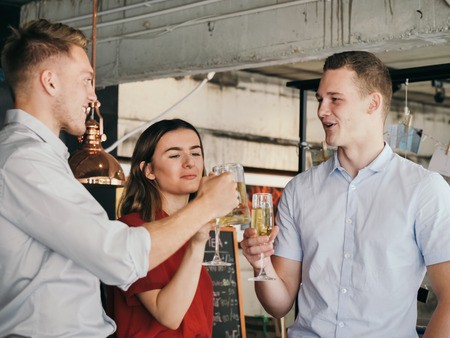 Successful young business men and businesswoman celebrating with champagne in cafeの写真素材