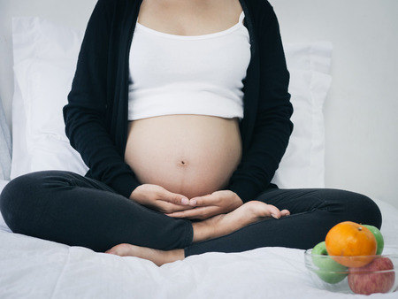 Pregnant woman doing yoga at home, lifestyle concept.の写真素材