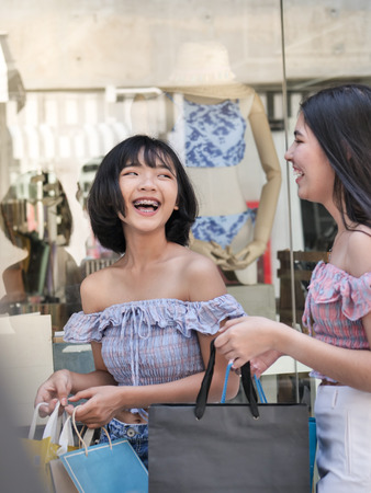 Happy Asian teenager girls walking and holding shopping bags together, lifestyle concept.の写真素材